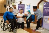 Group Head Region Central XLSMART Arif Farhan Budiyanto (dua kiri) bersama Head of Corporate Communication & CSR XLSMART sekaligus perwakilan Teman Pintar Indonesia Dani Miftahul Akhyar (tengah) dan Operation Director LAZ Darut Tauhid Peduli, Jajang Nurjaman (kanan) memberikan edukasi digital kepada dua orang penyandang disabilitas daksa saat pelatihan XLSMART Peduli Disabilitas Berdaya 2025 di Bandung, Jawa Barat, Selasa (17/6/2025). Pelatihan yang diikuti 20 peserta peyandang disabilitas tersebut merupakan rangkaian pelatihan sekitar 100 peserta dari berbagai provinsi di pulau Jawa, Sumatera, Kalimantan hingga Sulawesi sebagai praktik langsung pembuatan konten digital serta edukasi penerapan AI tools dalam strategi konten marketing digital. ANTARA FOTO/Novrian Arbi/agr