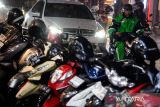 Pengemudi layanan transportasi daring (ojek online) melintasi kawasan Braga, Bandung, Jawa Barat, Selasa (17/6/2025). Kementerian Usaha Mikro, Kecil, dan Menengah menyatakan bahwa pengemudi layanan transportasi daring sebaiknya dikategorikan sebagai pelaku UMKM bukan pekerja dan karyawan tetap perusahaan aplikator guna memudahkan mereka memperoleh insentif dari negara, seperti pajak insentif UMKM hingga berbagai macam bantuan sosial dari Pemerintah. ANTARA FOTO/Novrian Arbi/agr