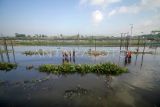Petugas memeriksa rel kereta api yang terendam di samping Jalan Raya Porong, Sidoarjo, Jawa Timur, Selasa (17/6/2025). Curah hujan yang tinggi sejak Senin (16/6) malam mengakibatkan banjir yang merendam rel kereta api dan jalan raya Porong setinggi 5070 cm. ANTARA FOTO/Umarul Faruq/tom.