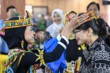 Wakil Menteri Pendidikan Tinggi, Sains dan Teknologi, Stella Christie (kanan) menerima ikat kepala khas Dayak dari siswa saat meninjau Sekolah Garuda Transformasi di SMAN 10 Samarinda, Kalimantan Timur, Rabu (18/6/2025). Kementerian Pendidikan Tinggi, Sains, dan Teknologi akan mengoptimalkan potensi Sekolah di 12 sekolah baik SMA dan MAN yang merupakan bagian dari Program Hasil Terbaik Cepat (PHTC) Presiden Prabowo Subianto terkait Asta Cita penguatan pembangunan sumber daya manusia Indonesia dan ekosistem sains dan teknologi. Antara Kaltim/M Risyal Hidayat