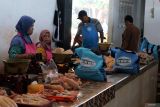 Pedagang menggunakan celemek bantuan Wakil Presiden Gibran Rakabuming Raka di Pasar Pon Kota Blitar, Jawa Timur, Rabu (18/6/2025). Wakil Presiden Gibran Rakabuming Raka dalam kunjungan kerjanya di Blitar membagikan ratusan paket sembako dan celemek kepada para pedagang di pasar tersebut. ANTARA Jatim/Irfan Anshori/mas.