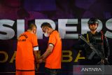 Anggota Brimob Polda Jabar menjaga tahanan kasus judi kasino saat rilis pengungkapan kasus judi kasino di Kosambi, Bandung, Jawa Barat, Rabu (18/6/2025). Polda Jabar mengungkap tempat judi kasino berkedok arena olahraga dan karaoke di Kota Bandung dan menangkap 44 tersangka beserta barang bukti berupa uang tunai Rp395 juta, kartu ATM dengan rekening berisi Rp2,7 milliar, dan meja kasino beserta perlengkapan judi. ANTARA FOTO/Raisan Al Farisi/agr