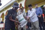 Bupati Tanjung Jabung Barat Anwar Sadat (kedua kanan) menyerahkan bantuan beras secara simbolis kepada salah seorang korban kebakaran di Sungai Dualap, Tanjung Jabung Barat, Jambi, Selasa (17/6/2025). Pemprov Jambi dan Pemkab Tanjung Jabung Barat menyerahkan bantuan alat tidur, sembako, dan beberapa peralatan sekolah untuk 122 korban kebakaran yang terpaksa mengungsi di rumah keluarga mereka pascakebakaran yang menghanguskan 54 rumah pada Senin (16/6/2025) siang. ANTARA FOTO/Wahdi Septiawan/foc.
