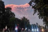 Pengendara motor melintas berlatar belakang awan panas erupsi Gunung Lewotobi Laki-laki di Maumere, Kabupaten Sikka, Nusa Tenggara Timur, Selasa (17/6/2025). Pos Pengamatan Gunung Api Lewotobi Laki-laki melapokan Â Gunung Lewotobi Laki-laki di Nusa Tenggara Timur kembali erupsi pada Selasa 17 Juni 2025 pukul 17.35 WITA dengan kolom abu teramati setinggi sekitar 10 Km di atas puncak atau setara 11.584 meter di atas permukaan laut. ANTARA FOTO/Arnoldine Shanon/sgd/foc.