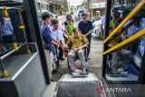 Petugas membantu warga untuk memasuki Bus Metro Trans Jabar saat peluncuran kartu multi trip di Stasiun Bandung, Jawa Barat, Kamis (19/6/2025). KAI Commuter Indonesia bekerja sama dengan Dinas Perhubungan Jawa Barat meluncurkan kartu multi trip yang dapat digunakan untuk transaksi pembayaran tiket Bus Metro Jabar Trans di Stasiun Bandung guna mempermudah penumpang untuk melakukan pembayaran. ANTARA FOTO/Raisan Al Farisi/agr