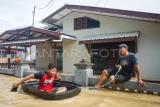 Warga bermain air saat banjir menggenangi kawasan permukiman di Kelurahan Damai, Balikpapan, Kalimantan Timur, Kamis (19/6/2025). Menurut data Badan Penanggulangan Bencana Daerah (BPBD) Kota Balikpapan hujan dengan intensitas sedang hingga lebat menyebabkan sedikitnya 24 titik di berbagai wilayah kota tersebut terendam banjir dengan ketinggian air mencapai 30 - 70 centimeter. Antara Kaltim/Aditya Nugroho/nym/mrh