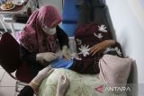 Petugas kesehatan memasang alat kontrasepsi jenis KB implan kepada akseptor saat pelayanan KB gratis di Puskesmas Taktakan, Kota Serang, Banten, Jumat (20/6/2025). Badan Kependudukan dan Keluarga Berencana Nasional (BKKBN) Provinsi Banten menggelar pelayanan KB gratis secara serentak di fasilitas kesehatan yang terdaftar di Kemendukbangga/BKKBN di seluruh Kabupaten/Kota se-Provinsi Banten dari 16 hingga 30 Juni 2025 dalam rangka memperingati Hari Keluarga Nasional ke-32 sekaligus sebagai upaya meningkatkan jumlah akseptor serta menguatkan komitmen dalam pengendalian laju pertumbuhan penduduk dan peningkatan kesejahteraan keluarga. ANTARA FOTO/Angga Budhiyanto/gp