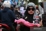 Seorang demonstran membawa replika jenazah, poster, spanduk  dan bendera saat damai  membela Palestina di Bundaran Simpang Lima, Banda Aceh, Aceh, Minggu (22/6/2025).  Sekitar tiga ribu masyarakat dari berbagai daerah di Provinsi Aceh itu turun ke jalan menggelar aksi damai mendesak PBB dan sejumlah negara memberikan kemerdekaan untuk Palestina dari penjajahan zionis Israel . ANTARA FOTO/Ampelsa