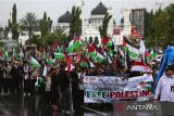 Sejumlah demonstran dari berbagai elemen masyarakat membawa poster, spanduk  dan bendera menggelar aksi long march bela Palestina di kawasan Masjid Raya Baiturrahman, Banda Aceh, Aceh, Minggu (22/6/2025).  Sekitar tiga ribu masyarakat dari berbagai daerah di provinsi Aceh itu turun ke jalan menggelar aksi damai mendesak PBB dan sejumlah negara memberikan kemerdekaan untuk Palestina dari penjajahan zionis  Israel . ANTARA FOTO/Ampelsa.