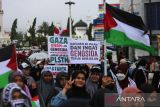 Sejumlah demonstran dari berbagai elemen masyarakat membawa poster, spanduk  dan bendera menggelar aksi long march bela Palestina di Bundaran Simpang Lima, Banda Aceh, Aceh, Minggu (22/6/2025).  Sekitar tiga ribu masyarakat dari berbagai daerah di provinsi Aceh itu turun ke jalan menggelar aksi damai mendesak PBB dan sejumlah negara memberikan kemerdekaan untuk Palestina dari penjajahan zionis  Israel . ANTARA FOTO/Ampelsa.