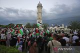 Sejumlah demonstran dari berbagai elemen masyarakat membawa poster, spanduk  dan bendera menggelar aksi long march  di  kawasan Masjid Raya Baiturrahman, Banda Aceh, Aceh, Minggu (22/6/2025).  Sekitar tiga ribu masyarakat dari berbagai daerah di provinsi Aceh itu turun ke jalan menggelar aksi damai mendesak PBB dan sejumlah negara memberikan kemerdekaan untuk Palestina dari penjajahan zionis  Israel . ANTARA FOTO/Ampelsa.