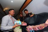 Jaksa mengawasi proses penyimpanan uang pengganti oleh petugas bank saat rilis perkembangan penyidikan kasus korupsi pembangunan penahan aliran sungai (DAM) Sungai Bentak Blitar dengan perkiraan kerugian negara sebesar Rp5,1 miliar di aula Kejaksaan Kabupaten Blitar, Jawa Timur, Senin (23/6/2025). Selain menerima penyerahan uang titipan pengganti sebesar Rp 1,1 miliyar dari tersangka berinisial MM, jaksa tipikor juga menunjukkan barang bukti tiga unit mobil yang disita dari tersangka lain berinisial HB yang diperkiran bernilai lebih dari Rp 1 miliyar. sebagai upaya memulihkan kerugian negara akibat korupsi ANTARA Jatim/Irfan Anshori/mas.