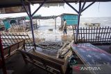 Warga melihat lapak pedagang yang rusak akibat diterjang gelombang pasang di pantai wisata Karangsong, Indramayu, Jawa Barat, Selasa (24/6/2025). Akibat terjangan gelombang pasang yang terjadi sejak sebulan terakhir menyebabkan abrasi dan banyak rumah warga serta lapak pedagang di wilayah itu mengalami kerusakan dan terkubur pasir yang terbawa air laut. ANTARA FOTO/Dedhez Anggara/agr
