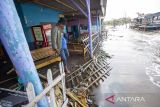 Warga melihat lapak pedagang yang rusak akibat diterjang gelombang pasang di pantai wisata Karangsong, Indramayu, Jawa Barat, Selasa (24/6/2025). Akibat terjangan gelombang pasang yang terjadi sejak sebulan terakhir menyebabkan abrasi dan banyak rumah warga serta lapak pedagang di wilayah itu mengalami kerusakan dan terkubur pasir yang terbawa air laut. ANTARA FOTO/Dedhez Anggara/agr