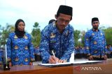Pegawai Pemerintah dengan Perjanjian Kerja (PPPK) Sandy Haryono (tengah) menandatangani perjanjian kerja pada upacara penyerahan surat keputusan pengangkatan di Kantor Bupati Kubu Raya, Kalimantan Barat, Senin (23/6/2025). Sebanyak 621 PPPK hasil seleksi tahun 2024 menerima surat keputusan pengangkatan untuk bertugas secara responsif dan profesional di lingkungan Pemerintah Kabupaten Kubu Raya mulai 1 Juli 2025. ANTARA FOTO/Jessica Wuysang