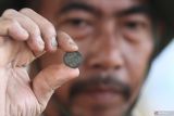Arkeolog dari Balai Pelestarian Kebudayaan XI menunukkan uang kuno yang ditemukan saat eskavasi penyelamatan  situs Balekambang di Landungsari, Malang, Jawa Timur, Rabu (25/6/2025). Selain uang kuno, dalam eskavasi tahap awal tersebut juga ditemukan struktur batu bata dan pecahan gerabah yang diduga merupakan peninggalan pada masa klasik Hindu Budha. ANTARA Jatim/Ari Bowo Sucipto/mas.