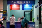 Petugas kesehatan melayani pasien untuk melakukan penukaran obat di Unit Pelaksana Teknis Daerah (UPTD) Puskesmas Sukahaji, Bandung, Jawa Barat, Rabu (25/6/2025). Pemerintah Kota Bandung meluncurkan program Integrasi Layanan Primer (ILP) yang saat ini terlaksana di 40 Puskesmas di Kota Bandung dan ditargetkan akan mencapai 80 puskesmas pada akhir tahun 2025 guna mewujudkan transformasi kesehatan nasional yang menjadi penopang sistem kesehatan Indonesia. ANTARA FOTO/Raisan Al Farisi/agr
