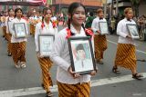 Peserta membawa foto para pahlawan melintas saat Kirab Budaya Mojo bangkit di jalan kawasan Kota Mojokerto, Jawa Timur, Kamis (26/6/2025). Kirab yang menampilkan Berbagai seni budaya dan sejarah dalam bentuk parade tersebut dalam rangka memperingati Hari Jadi ke 107 Kota Mojokerto dan refleksi peneguhan komitmen seluruh elemen kota untuk melangkah lebih maju dengan semangat Majapahit. Antara Jatim/Umarul Faruq