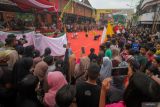 Warga menyaksikan seni bantengan saat Kirab Budaya Mojo bangkit di jalan kawasan Kota Mojokerto, Jawa Timur, Kamis (26/6/2025). Kirab yang menampilkan Berbagai seni budaya dan sejarah dalam bentuk parade tersebut dalam rangka memperingati Hari Jadi ke 107 Kota Mojokerto dan refleksi peneguhan komitmen seluruh elemen kota untuk melangkah lebih maju dengan semangat Majapahit. Antara Jatim/Umarul Faruq