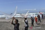 Peserta menerbangkan layang-layang saat festival sasawangan di Pantai Batu Hiu, Kabupaten Pangandaran, Jawa Barat, Kamis (26/6/2025). Festival Sasawang merupakan ajang permainan layang-layang tradisional bagi masyarakat pesisir pantai Selatan yang diikuti 35 peserta dari Pangandaran, Cilacap, dan Tasikmalaya untuk mempromosikan pariwisata di Pangandaran sekaligus melestarikan permainan layang-layang. ANTARA FOTO/Adeng Bustomi/agr