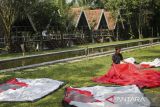 Pekerja menjemur tenda di Desa Wisata Bandung Bukit Sinyonya, Pandeglang, Banten, Kamis (26/6/2025). Kementerian Keuangan telah menyalurkan Dana Desa senilai Rp37,38 triliun atau setara dengan 46,38 persen dari total alokasi tahun ini sebesar Rp69 triliun untuk 75.259 desa di 37 provinsi per 19 Juni 2025 yang bertujuan untuk melindungi dan memberdayakan desa agar menjadi kuat, maju, mandiri, serta demokratis. ANTARA FOTO/Angga Budhiyanto/gp