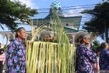 Warga mengarak gunungan dengan latar belakang Masjid Agung saat kirab budaya menyambut Tahu Baru Hijriah di Kota Kediri, Jawa Timur, Kamis (26/6/2025). Kirab budaya yang diikuti 46 kelurahan se-Kota Kediri tersebut sebagai perwujudan rasa syukur atas datangnya Tahun Baru Islam 1447 Hijriah sekaligus mempererat kerukunan masyarakat. ANTARA Jatim/Prasetia Fauzani/mas.