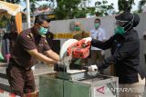 Kepala BNN Kota Pontianak Anida Sari (kanan) didampingi petugas Kejari memotong senjata tajam menggunakan mesin dalam kegiatan pemusnahan barang bukti di Kantor Kejaksaan Negeri Pontianak, Kalimantan Barat, Selasa (24/6/2025). Kejaksaan Negeri Pontianak memusnahkan sejumlah barang bukti berupa kosmetik dan obat herbal ilegal, senjata tajam, telepon genggam, pakaian dan narkotika dari 101 perkara yang telah berkekuatan hukum tetap (inkracht), yang mencakup tindak pidana Orang dan Harta Benda (Oharda), Tindak Pidana Umum Lainnya (TPUL), kepabeanan serta narkotika dan zat adiktif lainnya. ANTARA FOTO/Jessica Wuysang