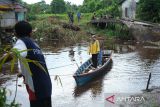 Dua warga menaiki perahu darurat melintasi lokasi jembatan ambruk di Desa Mega Timur, Kecamatan Sungai Ambawang, Kabupaten Kubu Raya, Kalimantan Barat, Rabu (25/6/2025). Jembatan penghubung Kabupaten Kubu Raya dan Kota Pontianak ambruk akibat struktur yang rapuh itu mengganggu aktivitas warga dan distribusi logistik, sehingga sekitar 80 kepala keluarga di Desa Mega Timur terpaksa menyeberang menggunakan perahu dengan bantuan tali tambang. ANTARA FOTO/Jessica Wuysang