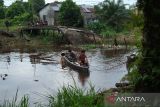 Dua warga menaiki perahu darurat melintasi lokasi jembatan ambruk di Desa Mega Timur, Kecamatan Sungai Ambawang, Kabupaten Kubu Raya, Kalimantan Barat, Rabu (25/6/2025). Jembatan penghubung Kabupaten Kubu Raya dan Kota Pontianak ambruk akibat struktur yang rapuh itu mengganggu aktivitas warga dan distribusi logistik, sehingga sekitar 80 kepala keluarga di Desa Mega Timur terpaksa menyeberang menggunakan perahu dengan bantuan tali tambang. ANTARA FOTO/Jessica Wuysang