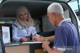 Petugas Bapenda Kota Pontianak melayani warga yang melakukan pembayaran Pajak Bumi dan Bangunan Perdesaan dan Perkotaan (PBB-P2) di mobil layanan keliling di Kelurahan Banjar Serasan, Pontianak, Kalimantan Barat, Rabu (25/6/2025). Badan Pendapatan Daerah (Bapenda) Kota Pontianak secara rutin setiap Senin hingga Kamis menggelar layanan keliling di setiap kelurahan untuk mempermudah masyarakat dalam mengurus pembayaran, pembaruan data PBB-P2 dan konsultasi pajak. ANTARA FOTO/Jessica Wuysang
