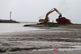 Pekerja mengoperasikan ekskavator untuk mengeruk sedimen di muara pelabuhan perikanan desa Lampulo, Banda Aceh, Aceh, Rabu (25/6/2025). Pengerukan muara pelabuhan yang mengalami sedimen itu merupakan swadaya dari masyarakat dan para nelayan untuk kelancaran lalulintas  ratusan kapal ikan yang datang dan pergi melaut, termasuk kapal angkutan pulau. ANTARA FOTO/Ampelsa.
