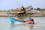 Kapal nelayan melintas saat pekerja mengoperasikan ekskavator untuk mengeruk sedimen di muara pelabuhan perikanan desa Lampulo, Banda Aceh, Aceh, Rabu (25/6/2025). Pengerukan muara pelabuhan yang mengalami sedimen itu merupakan swadaya dari masyarakat dan para nelayan untuk kelancaran lalulintas  ratusan kapal ikan yang datang dan pergi melaut, termasuk kapal angkutan pulau. ANTARA FOTO/Ampelsa.