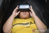 Seorang anak menggunakan perangkat virtual reality saat menyaksikan kisah nabi di Masjid Raya Al-Azhom, Kota Tangerang, Banten, Jumat (27/6/2025). Wahana virtual reality lima dimensi tersebut menyajikan pilihan film perjalanan kisah nabi, penciptaan alam semesta serta pembangunan Makkah berdurasi 8-12 menit dengan biaya Rp111 ribu dan berlangsung hingga 6 Juli 2025. ANTARA FOTO/Putra M. Akbar/gp