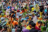 Warga berebut gunungan saat Grebeg Suro di Hutan Bambu, Desa Sumbermujur, Kecamatan Candipuro, Lumajang, Jawa Timur, Jumat (27/6/2025). Tradisi Grebeg Suro dengan arakan gunungan dan memendam kepala sapi di titik sumber air tersebut dilakukan sejumlah masyarakat sekitar kaki Gunung Semeru setiap tahun pada satu Suro dalam penanggalan Jawa sebagai ungkapan rasa syukur akan sumber air yang melimpah. ANTARA Jatim/Irfan Sumanjaya/mas.