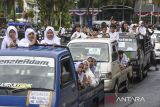 Kafilah menggunakan mobil bak terbuka mengikuti pawai ta'aruf di Kabupaten Ciamis, Jawa Barat, Sabtu (28/6/2025). Pawai yang menggunakan mobil, truk, bak terbuka dan sepeda motor itu diikuti ribuan santri se-Ciamis tersebut dalam rangka menyambut Tahun Baru Islam 1 Muharram 1447 Hijriah. ANTARA FOTO/Adeng Bustomi/agr