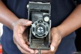 Kolektor memperlihatkan kamera fotografi kuno dalam pameran bertajuk Malang Djadoel #2 di Taman Krida Budaya, Malang, Jawa Timur, Senin (30/6/2025). Pameran yang digelar selama tujuh hari itu menampilkan berbagai benda antik mulai keris peninggalan Kerajaan Singhasari hingga kamera fotografi buatan 1956 guna mengenalkan nilai sejarah dan budaya kepada masyarakat, khususnya generasi muda. ANTARA FOTO/Ari Bowo SuciptoANTARA FOTO/ARI BOWO SUCIPTO (ANTARA FOTO/ARI BOWO SUCIPTO)