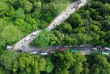 Foto udara antrean kendaraan saat bergantian melintasi tanjakan Sitinjau Lauik di Padang, Sumatera Barat, Senin (30/6/2025). Kemacetan panjang mencapai empat kilometer sejak Minggu (29/6) itu terjadi akibat sejumlah kendaraan besar seperti truk mengalami kerusakan saat melintasi tanjakan khususnya di kawasan Panorama Satu yang dikenal ekstrem dan berbahaya. ANTARA FOTO/Iggoy el Fitra/nym.