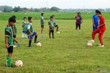 Evan Dimas melatih SSB di Tulungagung. Mantan Kapten Timnas U-19 Evan Dimas (kanan) melatih siswa SSB Saraswati dasar-dasar bermain bola di Lapangan Desa Mojoarum, Tulungagung, Jawa Timur, Kamis (19/6/2025). Sejak dilepas Persik Kediri pertengahan musim lalu, Evan memilih fokus menekuni dunia kepelatihan dengan merintisnya di SSB Saraswati yang memiliki lebih dari 20 siswa dan menolak tawaran bermain di beberapa club nasional. Antara Jatim/Destyan Sujarwoko/um