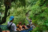 Wisatawan menuruni tangga saat mengunjungi wisata Tumpak Sewu di Lumajang, Jawa Timur, Selasa (1/7/2025). Menanggapi beberapa laporan video yang sempat viral terkait pungutan liar di wisata Coban Sewu Wakil Menteri Pariwisata Ni Luh Puspa menyebutkan bahwa wisatawan hanya perlu membayar satu tiket saja dan bisa melaporkan kepada instansi terkait jika menemui aksi pungli di wisata tersebut. Antara Jatim/Irfan Sumanjaya/um