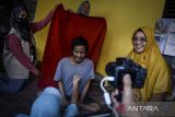 Petugas memotret warga penyandang disabilitas mental untuk pembuatan KTP elektronik di Kunciran, Pinang, Kota Tangerang, Banten, Selasa (1/7/2025). Pelayanan perekaman data KTP elektronik dengan cara jemput bola tersebut guna mempermudah penyandang disabilitas agar terdaftar dalam administrasi kependudukan sebagai syarat untuk mendapatkan layanan publik hingga program pemerintah. ANTARA FOTO/Putra M. Akbar/gp