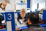 Petugas customer service melayani pensiunan untuk mengoperasikan aplikasi Andal by Taspen di PT Taspen (Persero) Kantor Cabang Bandung, Jawa Barat, Selasa (1/7/2025). PT Taspen (Persero) mencatat hingga 1 Juli 2025 sebanyak 2 juta peserta telah menggunakan aplikasi Andal by Taspen yang ditujukan sebagai salah satu layanan bagi penerima program pensiun untuk melakukan autentikasi tanpa harus mengunjungi mitra bayar atau Kantor Cabang Taspen. ANTARA FOTO/Raisan Al Farisi/agr