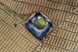 Foto udara kondisi kolam penampungan air di lahan pertanian Bumiaji, Batu, Jawa Timur, Rabu (2/7/2025). Akibat tidak adanya sumber mata air di lahan pertanian tersebut, sejumlah petani di kawasan lereng Gunung Arjuno mulai menampung air yang dipompa dari aliran sungai sejauh enam kilometer dengan biaya sekitar Rp2,5 juta per bulan untuk lahan seluas 1,5 hektar guna mengantisipasi puncak musim kemarau yang diprediksi BMKG terjadi pada sekitar bulan Agustus. Antara Jatim/Muhammad Mada/um