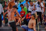 Dua warga bergantian saling menyabet menggunakan rotan saat tradisi Ojung di Desa Nguter, Kecamatan Pasirian, Lumajang, Jawa Timur, Rabu (2/7/2025). Tradisi Ojung tersebut digelar rutin tiap setahun sekali saat selamatan desa yang biasanya diperingati saat bulan Suro pada penanggalan Jawa dalam rangka menjaga tradisi dan budaya setempat. Antara Jatim/Irfan Sumanjaya/um