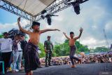 Dua anak menari disela bergantian saling menyabet menggunakan rotan saat tradisi Ojung di Desa Nguter, Kecamatan Pasirian, Lumajang, Jawa Timur, Rabu (2/7/2025). Tradisi Ojung tersebut digelar rutin tiap setahun sekali saat selamatan desa yang biasanya diperingati saat bulan Suro pada penanggalan Jawa dalam rangka menjaga tradisi dan budaya setempat. Antara Jatim/Irfan Sumanjaya/um