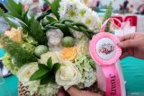 Peserta merapikan hasil karya rangkaian bunga meja miliknya saat Specta Flora Festival di wisata Baloga, Batu, Jawa Timur, Sabtu (5/7/2025). Agenda yang diikuti puluhan pelaku usaha kerajinan bunga hias dan penghobi dari berbagai daerah itu diinisiasi pemerintah setempat sebagai upaya meningkatkan perekonomian khususnya bagi pelaku UMKM dan petani bunga di kawasan tersebut. ANTARA Jatim/Muhammad Mada/mas.
