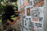 Seorang mahasiswa menempel poster di tiang baliho saat mengikuti Aksi Kamisan Pontianak #60 di Taman Digulis Universitas Tanjungpura, Pontianak, Kalimantan Barat, Kamis (3/7/2025). Dalam aksi tersebut mereka menyerukan isu reformasi Polri dan mendesak pemerintah menuntaskan kasus-kasus pelanggaran HAM yang terjadi di Indonesia. ANTARA FOTO/Jessica Wuysang