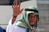 Jamaah haji dari kelompok terbang (kloter) 21 melambaikan tangan saat tiba di Asrama Haji Pontianak, Kalimantan Barat, Minggu (6/7/2025). Sebanyak 437 jamaah haji dan empat petugas haji asal Kabupaten Sambas dan Kubu Raya, Kalimantan Barat yang tergabung dalam kloter 21 tiba di Pontianak usai menunaikan ibadah haji di Tanah Suci Mekkah. ANTARA FOTO/Jessica Wuysang