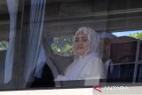 Jamaah haji dari kelompok terbang (kloter) 21 duduk di dalam bus Damri saat tiba di Asrama Haji Pontianak, Kalimantan Barat, Minggu (6/7/2025). Sebanyak 437 jamaah haji dan empat petugas haji asal Kabupaten Sambas dan Kubu Raya, Kalimantan Barat yang tergabung dalam kloter 21 tiba di Pontianak usai menunaikan ibadah haji di Tanah Suci Mekkah. ANTARA FOTO/Jessica Wuysang