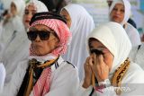 Jamaah haji dari kelompok terbang (kloter) 21 menjalani acara penyambutan saat tiba di Asrama Haji Pontianak, Kalimantan Barat, Minggu (6/7/2025). Sebanyak 437 jamaah haji dan empat petugas haji asal Kabupaten Sambas dan Kubu Raya, Kalimantan Barat yang tergabung dalam kloter 21 tiba di Pontianak usai menunaikan ibadah haji di Tanah Suci Mekkah. ANTARA FOTO/Jessica Wuysang