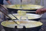 Petugas mengambil bubur yang telah matang pada tradisi Bubur Asyura di Langgar Al-Falah di kawasan Muso Salim, Samarinda, Kalimantan Timur, Minggu (6/7/2025). Tradisi bubur Asyura yang merupakan akulturasi Islam dan budaya riparian untuk memperingati 10 Muharram dengan membagikan sekitar 3.000 porsi bubur kepada warga sekitar sebagai wujud rasa syukur kepada Tuhan atas limpahan rezeki dan kesehatan. Antara Kaltim/M Risyal Hidayat